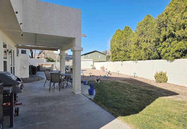 view of patio / terrace with area for grilling, a fenced backyard, and a jacuzzi