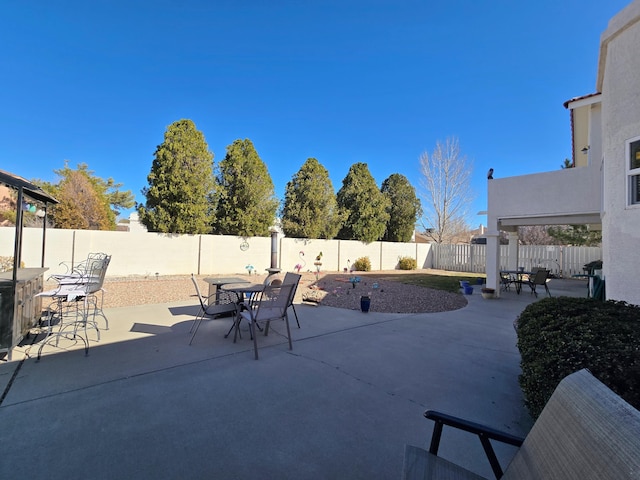 view of patio with a bar and a fenced backyard