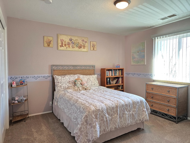 bedroom with carpet floors, baseboards, visible vents, and a textured ceiling