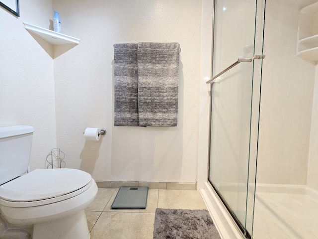 full bathroom with baseboards, a stall shower, toilet, and tile patterned floors