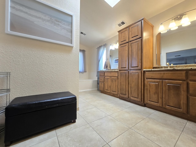 bathroom featuring visible vents, a garden tub, vanity, and tile patterned floors