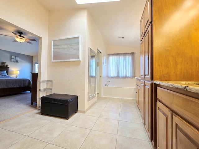 bathroom with ensuite bathroom, tile patterned flooring, vanity, visible vents, and a bath