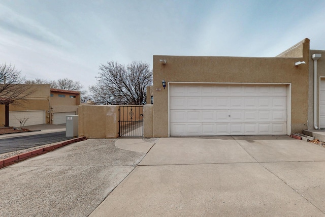 garage with a gate and driveway