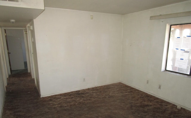 unfurnished room with visible vents and dark colored carpet