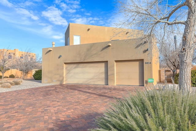 5524 Poblanos Ct NW, Albuquerque, NM 87107 - view of side of home with stucco siding, decorative driveway, and a garage