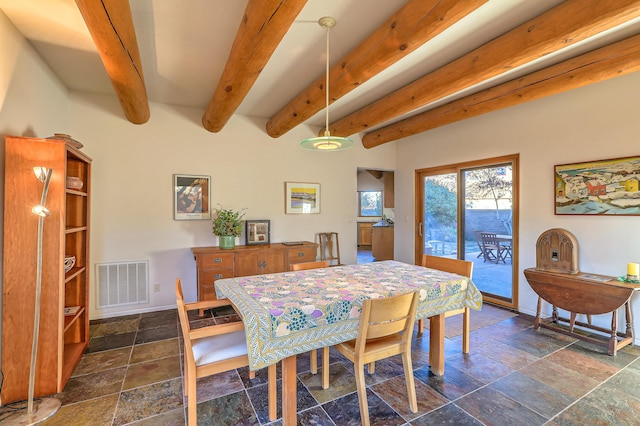 dining area featuring stone tile flooring, visible vents, baseboards, and beam ceiling