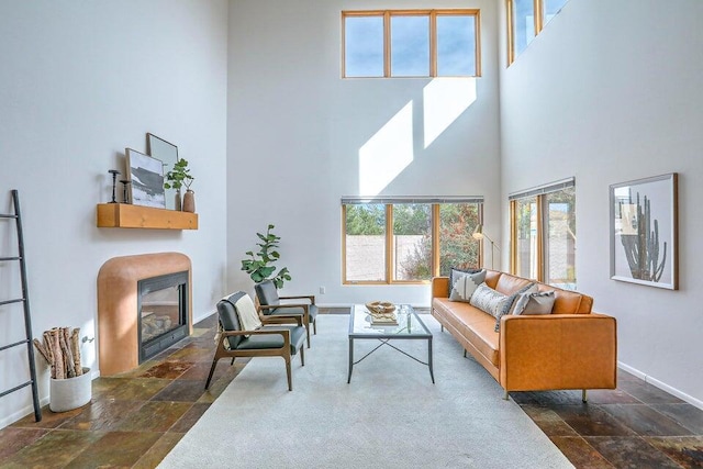 5524 Poblanos Ct NW, Albuquerque, NM 87107 - living area with a high ceiling, stone tile floors, and a glass covered fireplace