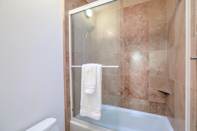 full bath featuring shower / bath combination with glass door and toilet