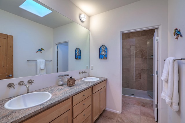 bathroom with a stall shower, a skylight, a sink, and double vanity