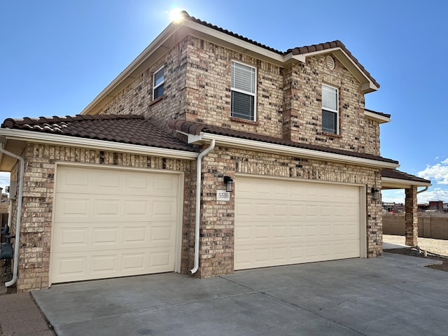 view of front of home featuring a tiled roof, a garage, and driveway