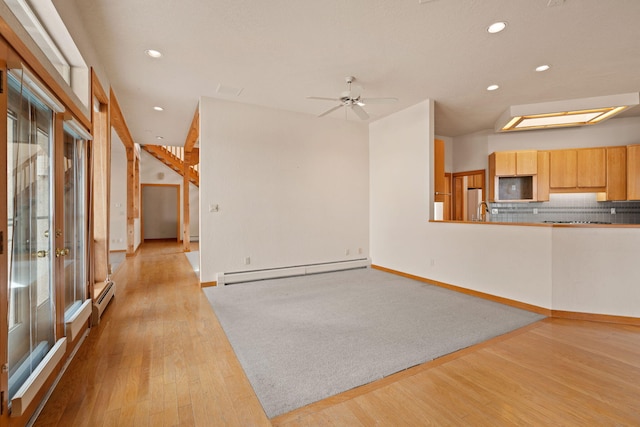 unfurnished living room featuring a baseboard heating unit, recessed lighting, baseboards, and light wood-style floors