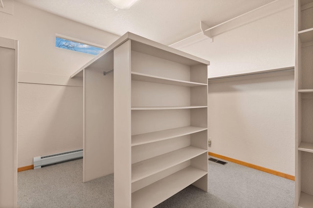 spacious closet featuring light carpet, baseboard heating, and visible vents