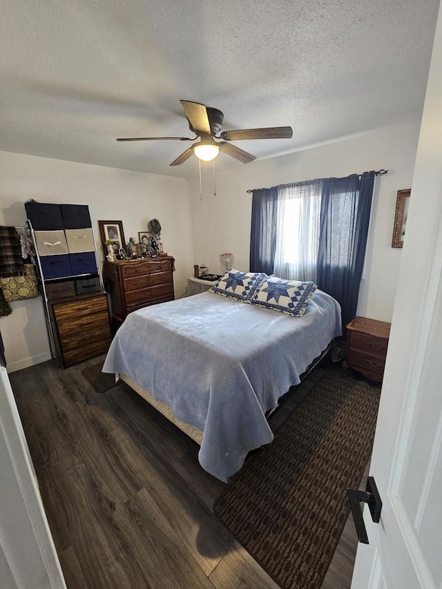 bedroom with a ceiling fan, dark wood finished floors, and a textured ceiling