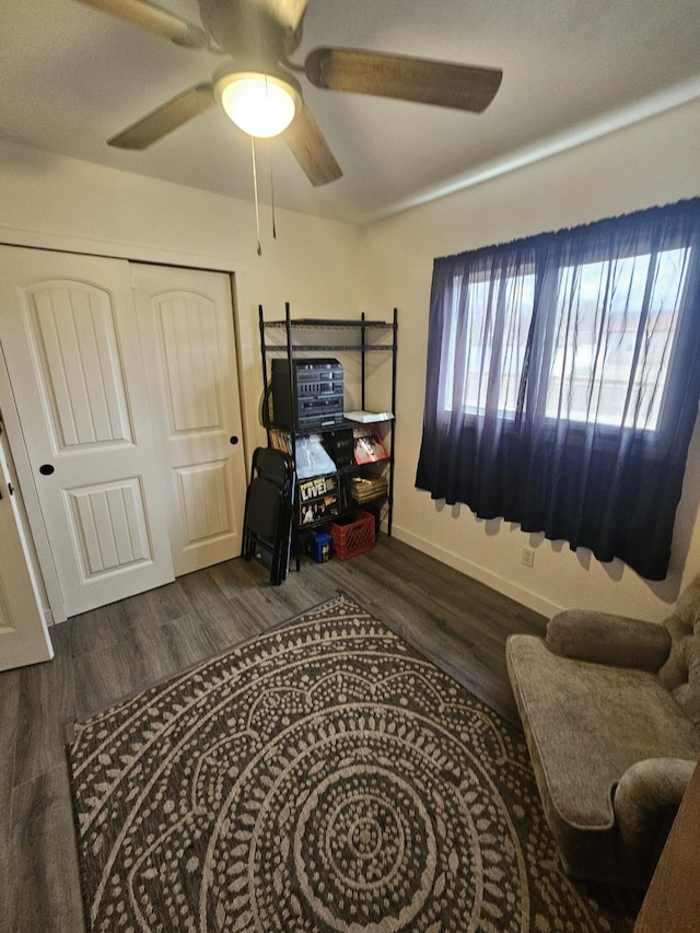 bedroom featuring dark wood-style flooring, a closet, a ceiling fan, and baseboards