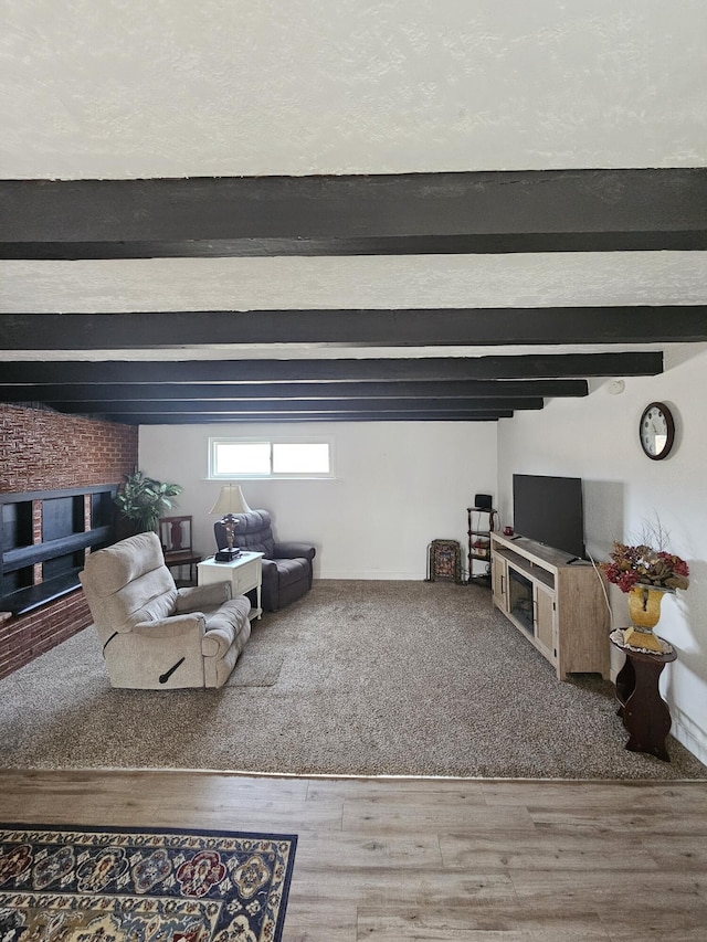 living room featuring a textured ceiling, beam ceiling, and wood finished floors