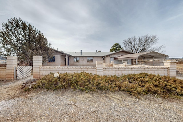 ranch-style home featuring fence and brick siding