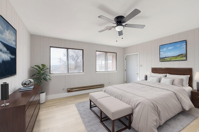 bedroom featuring light wood-type flooring, a baseboard radiator, and a ceiling fan