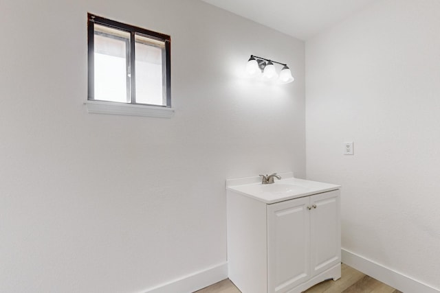 bathroom with vanity, baseboards, and wood finished floors