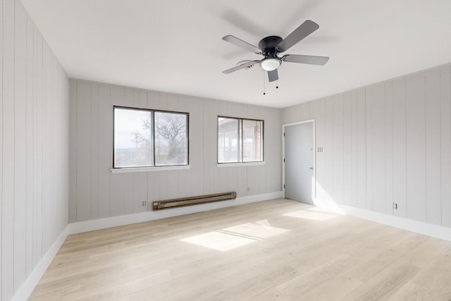 empty room with light wood-style floors, a baseboard radiator, baseboards, and a ceiling fan