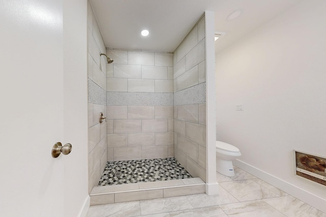 bathroom with recessed lighting, a tile shower, toilet, and baseboards