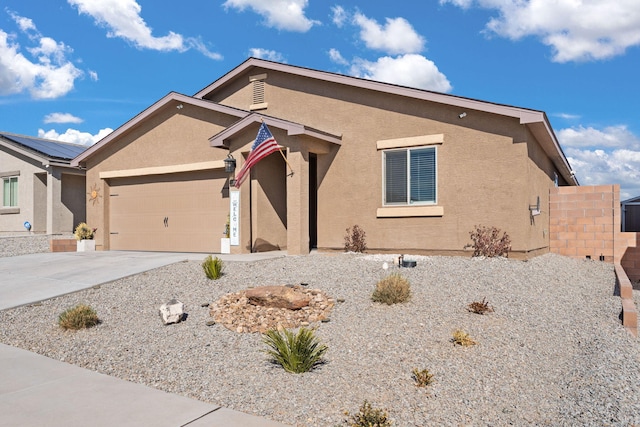 ranch-style home featuring a garage, concrete driveway, and stucco siding