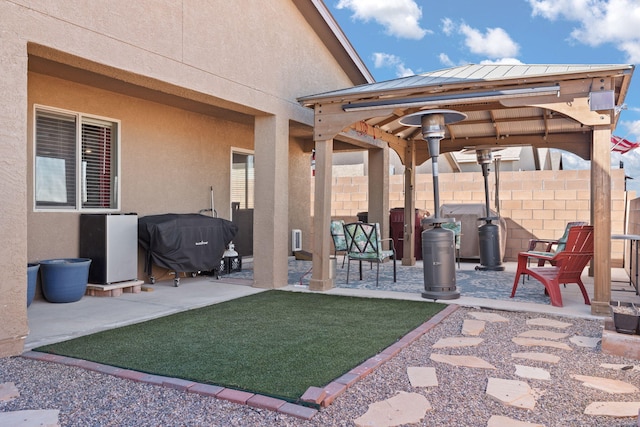 view of patio featuring fence, grilling area, and a gazebo