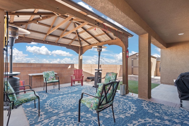 view of patio with a fenced backyard, an outdoor structure, a gazebo, and a storage unit