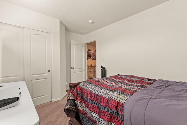 bedroom with light carpet, a closet, and baseboards