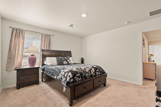 bedroom featuring light colored carpet, visible vents, a textured ceiling, and baseboards