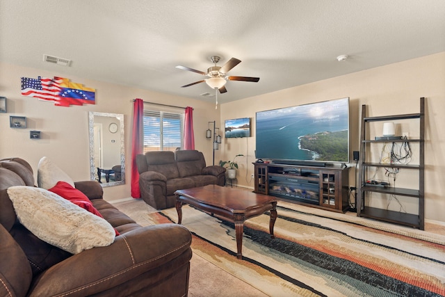 living room with visible vents, light carpet, ceiling fan, a textured ceiling, and baseboards