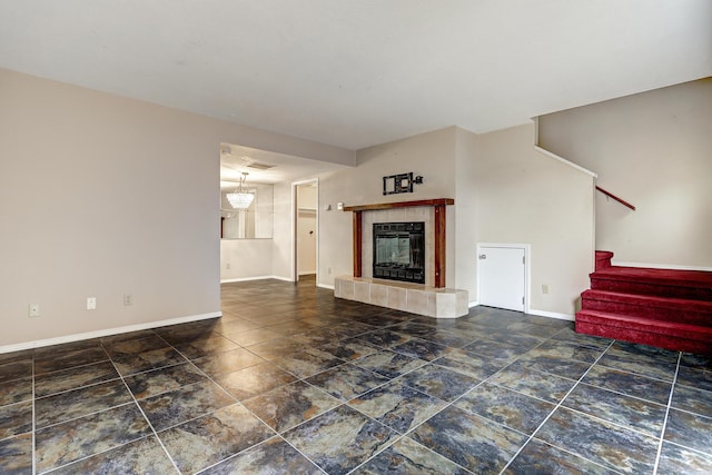 unfurnished living room featuring stairway, a fireplace, visible vents, and baseboards