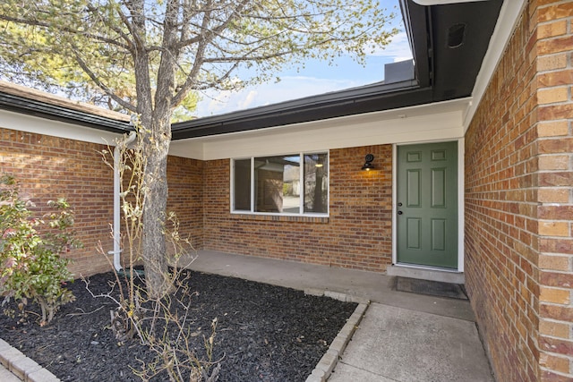 property entrance featuring brick siding