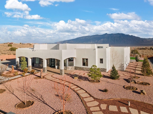 6316 La Paz Rd NE, Rio Rancho, NM 87144 - adobe home with stucco siding, a mountain view, stone siding, and a patio area