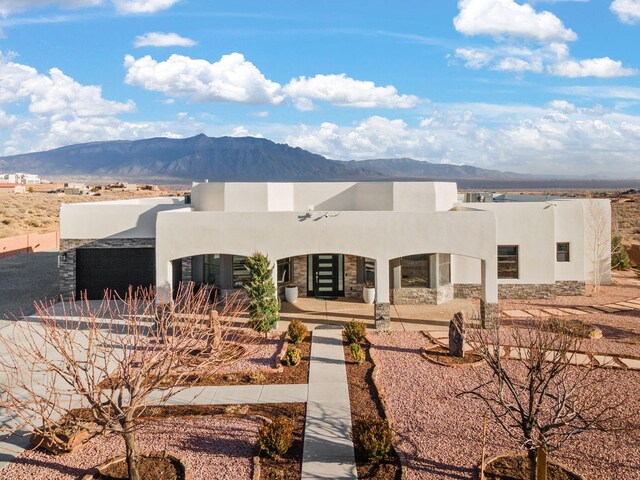 6316 La Paz Rd NE, Rio Rancho, NM 87144 - adobe home featuring a mountain view, stucco siding, and stone siding