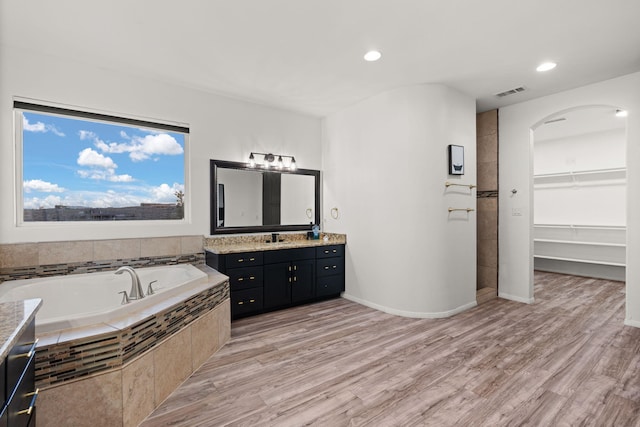 6316 La Paz Rd NE, Rio Rancho, NM 87144 - full bathroom featuring vanity, a garden tub, wood finished floors, recessed lighting, and a spacious closet