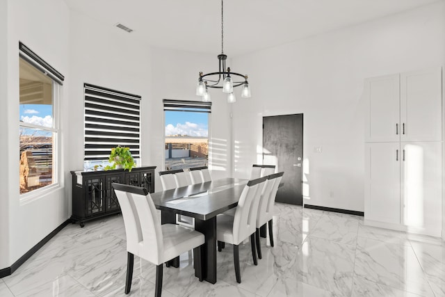 6316 La Paz Rd NE, Rio Rancho, NM 87144 - dining area featuring a chandelier, light marble finish floors, and baseboards