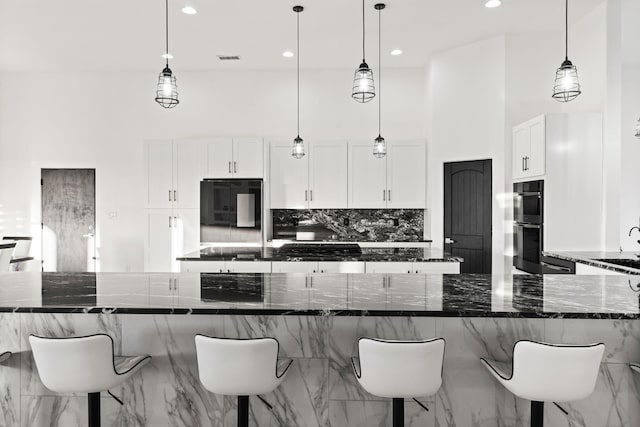 6316 La Paz Rd NE, Rio Rancho, NM 87144 - kitchen with double oven, refrigerator, tasteful backsplash, a kitchen bar, and recessed lighting