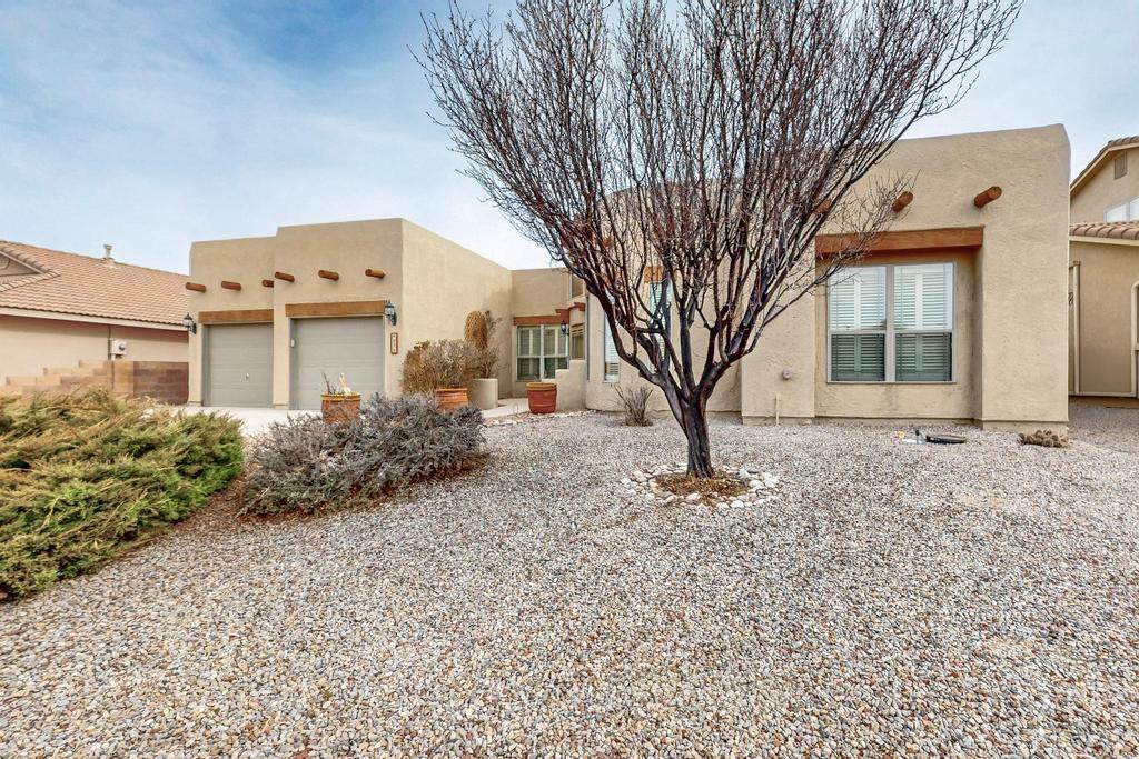 pueblo-style house featuring stucco siding and driveway