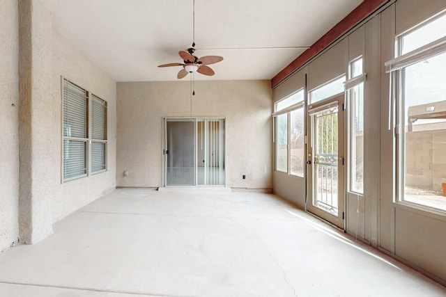 unfurnished sunroom with a ceiling fan