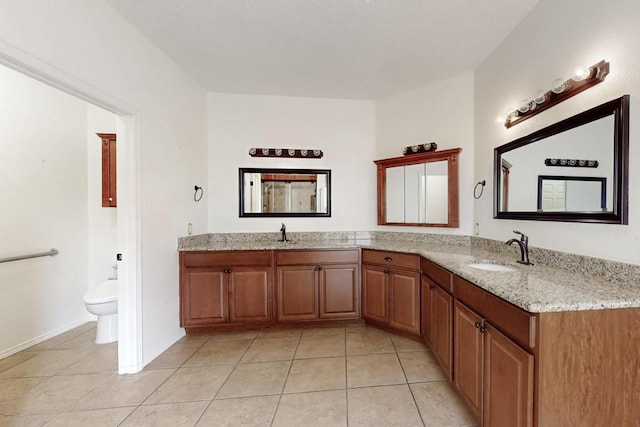 full bathroom featuring double vanity, a sink, toilet, and tile patterned floors