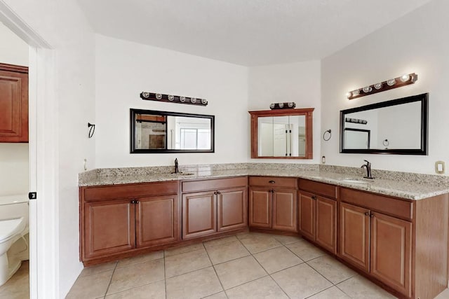 full bathroom featuring double vanity, a sink, and toilet