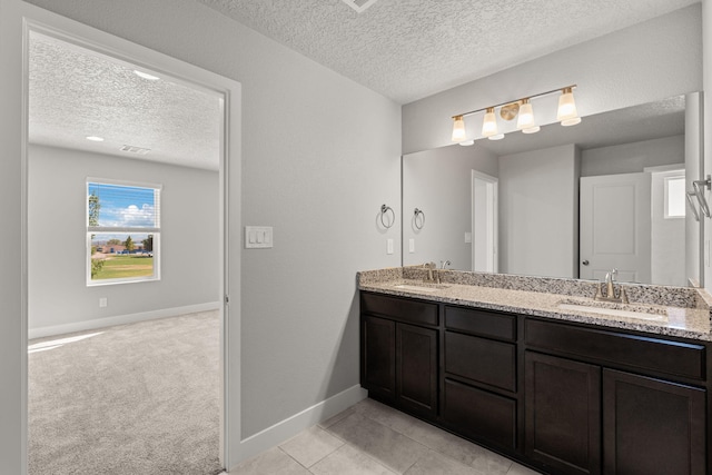 392 Pecos Loop SE, Rio Rancho, NM 87124 - full bath with a textured ceiling, baseboards, double vanity, and tile patterned floors