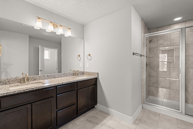 392 Pecos Loop SE, Rio Rancho, NM 87124 - bathroom with a textured ceiling, baseboards, a stall shower, double vanity, and tile patterned floors