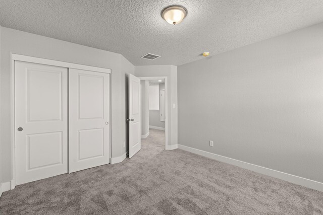 392 Pecos Loop SE, Rio Rancho, NM 87124 - unfurnished bedroom with carpet flooring, a closet, baseboards, and a textured ceiling