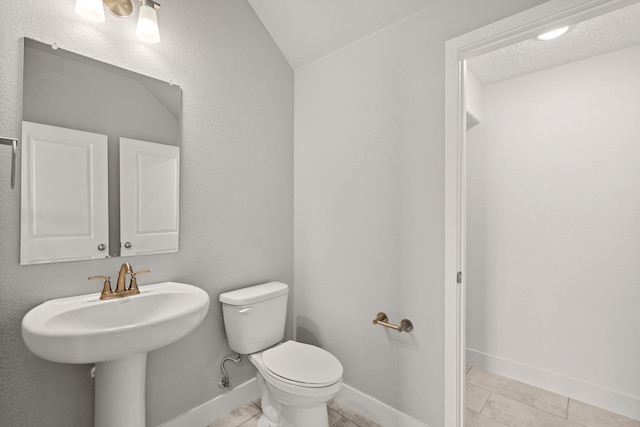 392 Pecos Loop SE, Rio Rancho, NM 87124 - bathroom with toilet, tile patterned flooring, a sink, baseboards, and lofted ceiling