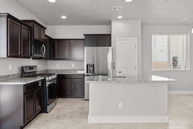 392 Pecos Loop SE, Rio Rancho, NM 87124 - kitchen with appliances with stainless steel finishes, a textured ceiling, a sink, light tile patterned floors, and light stone countertops