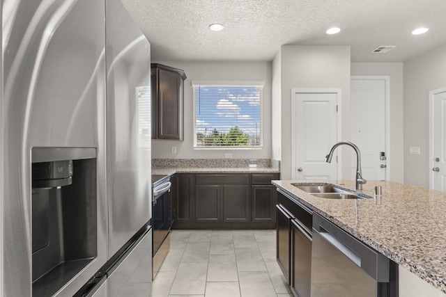 392 Pecos Loop SE, Rio Rancho, NM 87124 - kitchen with stainless steel appliances, a sink, light stone counters, light tile patterned flooring, and a textured ceiling