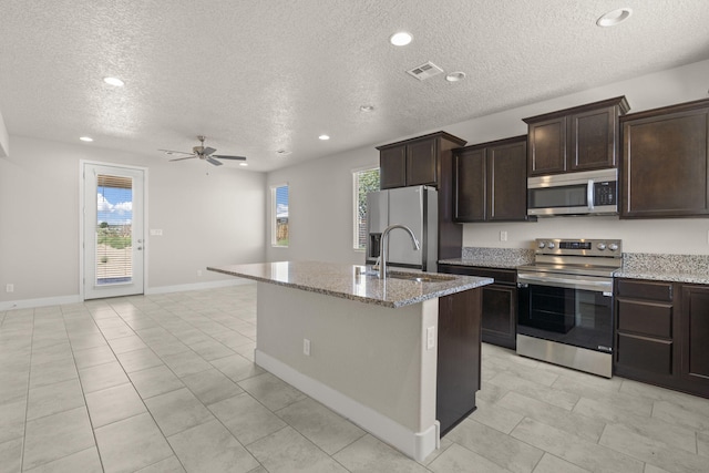 392 Pecos Loop SE, Rio Rancho, NM 87124 - kitchen featuring stainless steel appliances, light stone countertops, a textured ceiling, a sink, and ceiling fan