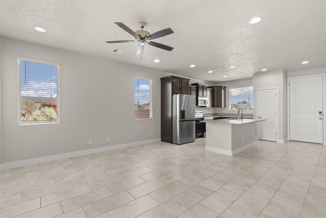 392 Pecos Loop SE, Rio Rancho, NM 87124 - kitchen with stainless steel appliances, a textured ceiling, healthy amount of natural light, recessed lighting, and open floor plan
