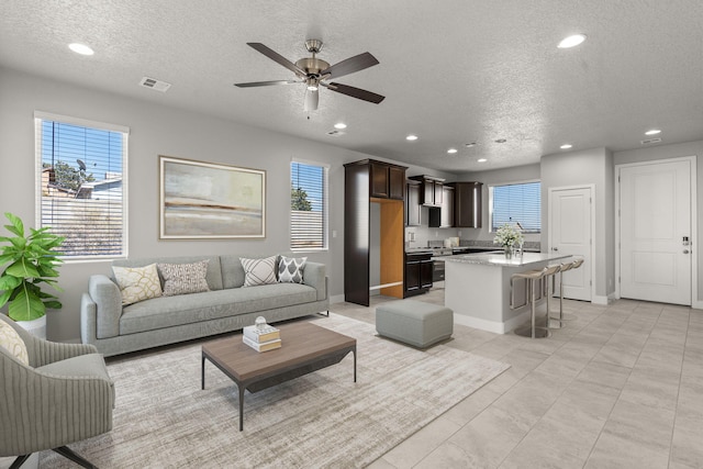 392 Pecos Loop SE, Rio Rancho, NM 87124 - living room with a textured ceiling, recessed lighting, a ceiling fan, baseboards, and light tile patterned floors